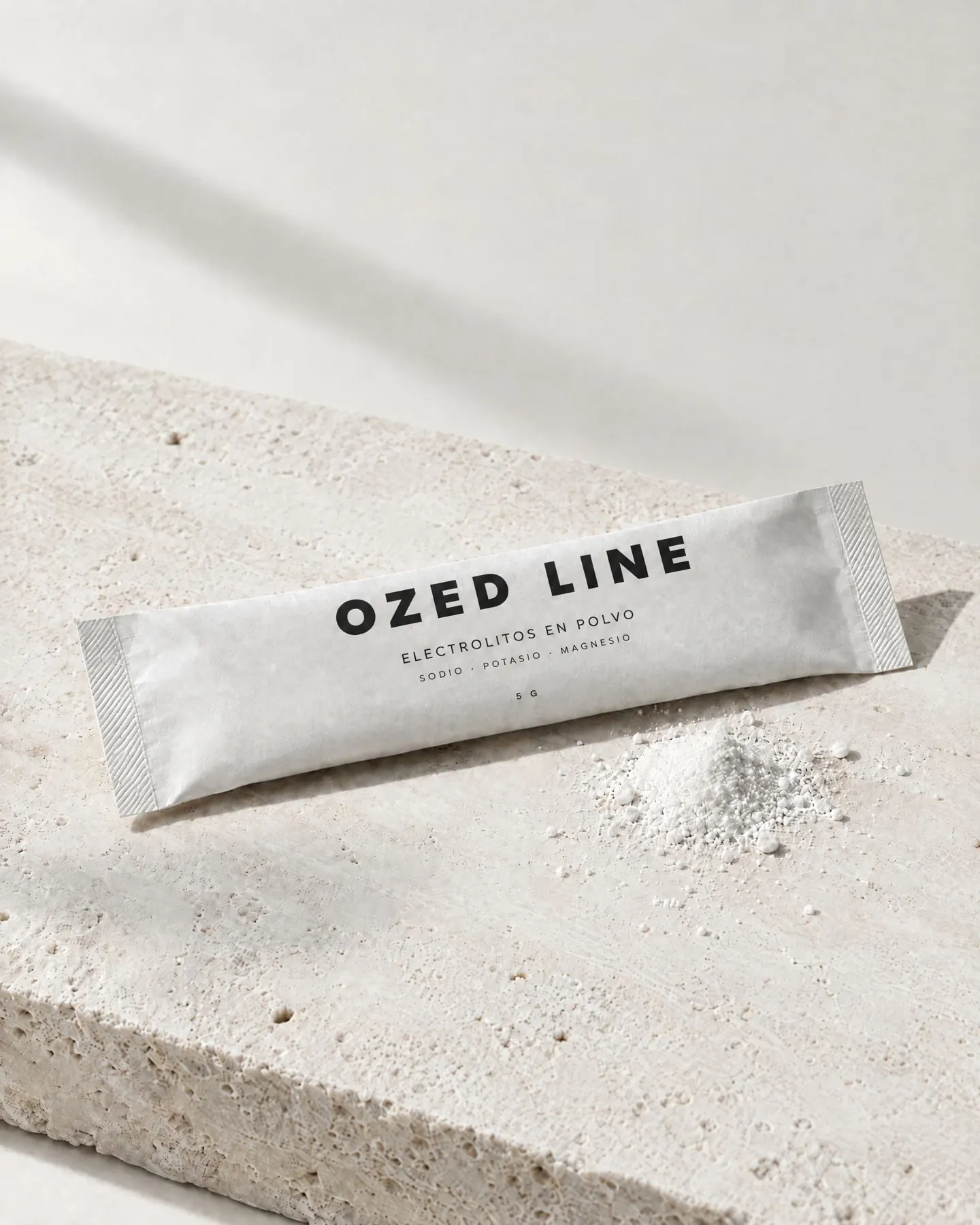 Sachet de electrolitos en polvo Ozed Line sobre piedra travertino